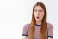 Close-up shocked and freak-out, concerned young serious-looking woman stare skeptical and confused, say what, open mouth Royalty Free Stock Photo