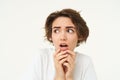 Close up of shocked, scared and worried young woman, trembling from fear, posing over white background