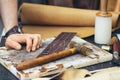 Close up of a shoemaker or artisan worker hands. Leather craft tools on old wood table Royalty Free Stock Photo