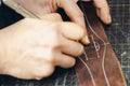 Close up of a shoemaker or artisan worker hands. Leather craft tools on old wood table Royalty Free Stock Photo