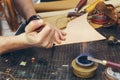 Close up of a shoemaker or artisan worker hands. Leather craft tools on old wood table Royalty Free Stock Photo