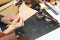 Close up of a shoemaker or artisan worker hands. Leather craft tools on old wood table Royalty Free Stock Photo