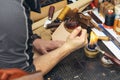 Close up of a shoemaker or artisan worker hands. Leather craft tools on old wood table Royalty Free Stock Photo