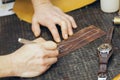 Close up of a shoemaker or artisan worker hands. Leather craft tools on old wood table Royalty Free Stock Photo