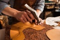 Close up of a shoemaker man working with leather