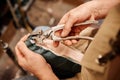 Close-up of shoemaking master using pliers to fix back part of boot