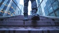 Close-up on the shoes of a professional ascending steps against the sunset backdrop in a bustling city environment.