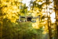 Close up shoot of a DJI Quadcopter Drone Mavic mini 249g. Drone flying in sunny forest. DJI is the market leader in drones and