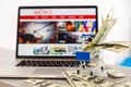 Close up shopping cart with dollar on a laptop keyboard. news