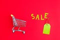 Close-up of shopping trolley on color background with some copy space. Black Friday. Shopping Price tags sale on a red background Royalty Free Stock Photo