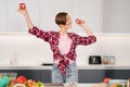 Close up. Short hair woman in red shirt playing with food, cut slices of sweet paper while cooking in the white kitchen Royalty Free Stock Photo