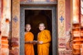 Two novices are standing reading books together in the temple. Royalty Free Stock Photo