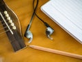 Close up shot of acoustic guitar with earphone Royalty Free Stock Photo