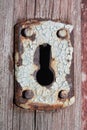 Close-up shot of an antique keyhole in a rusted iron plate on an old wooden door Royalty Free Stock Photo