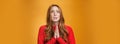 Close-up shot of anxious nervous and hopeless distressed cute redhead woman in red dress holding hands in pray looking