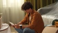 Close up shot of apartment living room. Man sitting on the floor holding eviction documents, shocked upset expression.