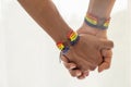 Close up shot of Asian Male couple holding hands with gay pride rainbow awareness wristbands. LGBT, same-sex love and homosexual