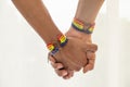 Close up shot of Asian Male couple holding hands with gay pride rainbow awareness wristbands. LGBT, same-sex love and homosexual