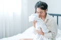 Close up shot of Asian mother kiss her newborn baby in front of white curtain in bedroom Royalty Free Stock Photo