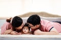 Close-up shot of Asian parents kissing the forehead of their 4-month-old newborn baby in a soft bed in the home`s bedroom with Royalty Free Stock Photo