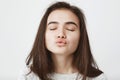 Close-up shot of attractive tender european woman waiting for kiss with folded lips and closed eyes. Girl waits till