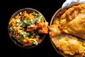 Close up shot of Batate ki sukhi bhaji or potato sabji in a clay bowl along with some dry plain fried puri and some cut onions on Royalty Free Stock Photo
