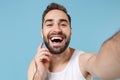 Close up shot bearded young man 20s years old in white shirt doing selfie isolated on blue pastel wall background