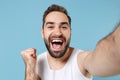 Close up shot bearded young man 20s years old in white shirt doing selfie isolated on blue pastel wall background