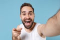 Close up shot bearded young man 20s years old in white shirt doing selfie isolated on blue pastel wall background