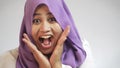 Close up shot of beautiful Asian muslim woman wearing hijab shows shocked excited expression, toothy smile, surprised to see somet