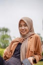 Asian woman wearing hijab sitting on park bench Royalty Free Stock Photo