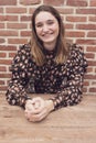 Close Up Shot of a Beautiful brown Haired Teenager smiling, against a red brick background with copy space Royalty Free Stock Photo