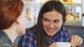 Beautiful young woman having coffee with her friend at the bakery shop Royalty Free Stock Photo