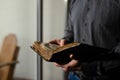 Close up shot bible. Alone male prayer reading old literature. Man in black shirt holding religious holy book. Hope for Royalty Free Stock Photo