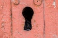 Close-up Shot Of A Big Keyhole On A Wooden Door painted red