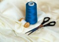 Close up shot of scissors and sewing threads on beige satin Royalty Free Stock Photo