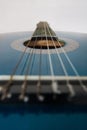 Close up shot of a blue acoustic guitar. Classical musical instrument, fingerboard and inlay of 6 strings