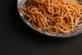 Close up shot of a bowl of cooked spaghetti isolated on a black background