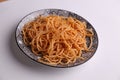 Close up shot of a bowl of cooked spaghetti isolated on a white background
