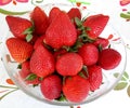 Close-up, shot of a bright red ripe, strawberry on a plate, with a white background Royalty Free Stock Photo