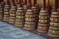 Close-up shot of buddhist prayer wheels in a row on a table Royalty Free Stock Photo