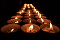 Close-up shot of burning tea candles in a dark