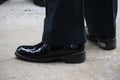 Close-up shot of a business man wearing slacks and black leather shoes standing on a cement floor, outdoor street, optional focus. Royalty Free Stock Photo