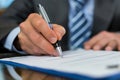 Close up shot of a businessman signing a business contract. Businessman writing on a paper document Royalty Free Stock Photo