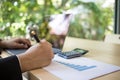 Close up shot of a businessman writing on charts paper at workstation. Modern business man writing on chart paper and using laptop Royalty Free Stock Photo