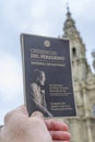 Close-up shot of Camino de Santiago pilgrim credential passport with cathedral in background