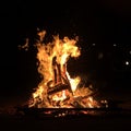 Close-up shot of a campfire with flames and smoke at a campsite at night