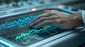 Hand Interacting With a Futuristic Digital Touchscreen Display, Visualizing Complex Blue and Green Data Waveforms And Graphs In a Royalty Free Stock Photo
