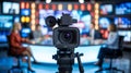 Television studio camera in focus capturing news broadcast with journalists interviewing Royalty Free Stock Photo