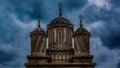 Close-up shot of The Cathedral of Curtea de Arges towers built by Manole in Romania,and black clouds